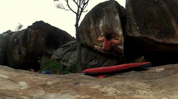 Eric malhando o boulder Chave de Coxa V8 em Ubatuba